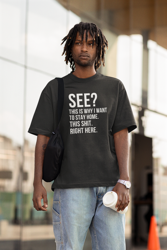 Young man holding a coffee cup wearing a shirt that says SEE?